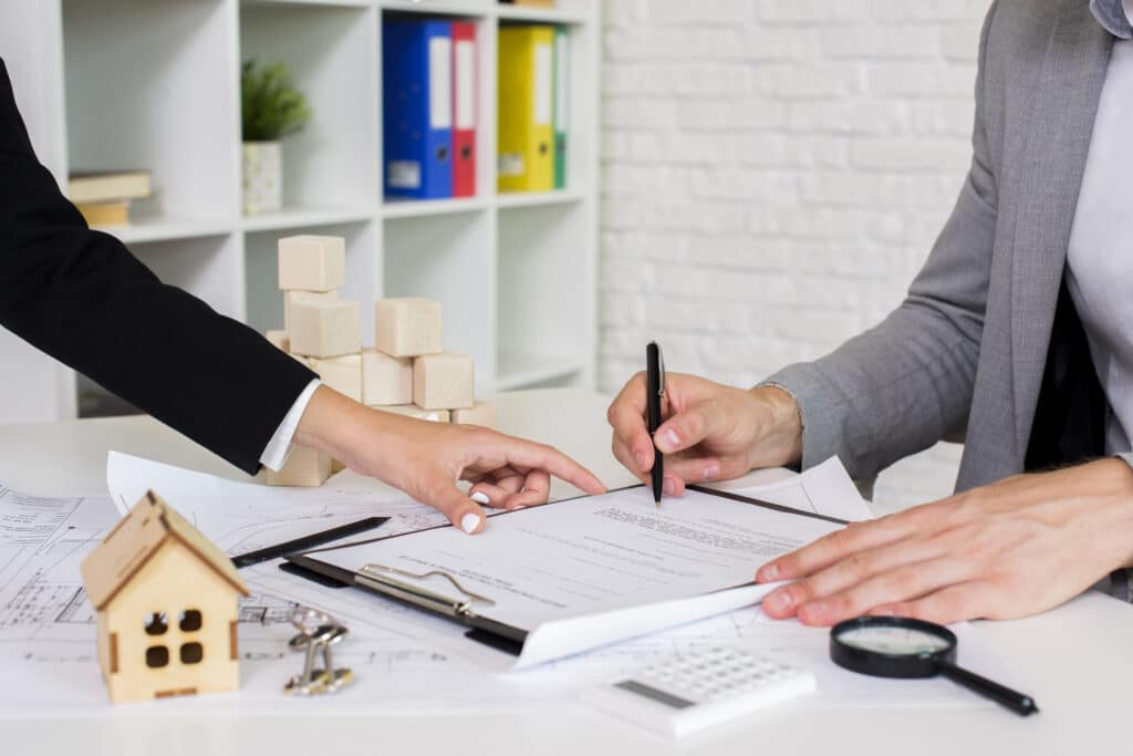 Legal professional explains property contract as client prepares to sign, with house keys and contract visible.