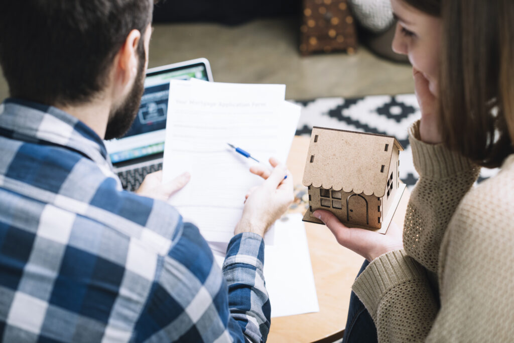 Couple reviewing house contract with concern, seeking to understand legal implications.
